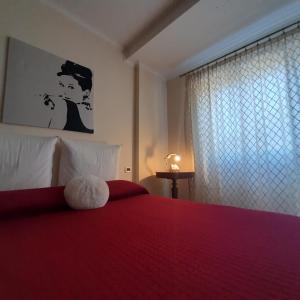 丽都迪奥斯蒂亚la passeggiata的一间卧室,配有一张红色的床,上面有泰迪熊