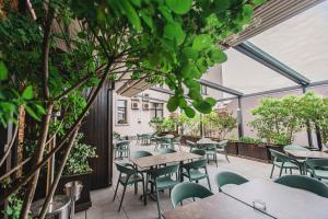 奥拉迪亚卡罗精品酒店的户外庭院配有桌椅和树木。