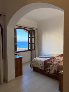 达哈布Dahab , property company Lighthouse area的一间卧室配有一张床,享有海景