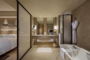 深圳深圳蛇口希尔顿南海酒店的带浴缸、床和盥洗盆的浴室