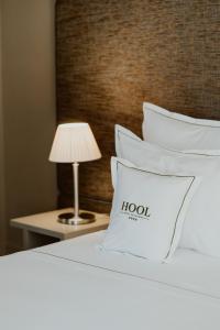 吉马良斯达奥利维拉酒店的酒店客房,配有带枕头和灯的床