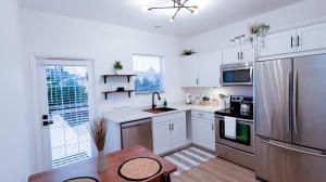 博尼塔斯普林斯Stunning 2 BR w/ private patio in perfect location的厨房配有白色橱柜和不锈钢冰箱