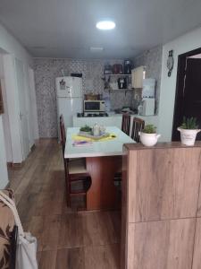 南圣弗朗西斯科Casa Praia Ubatuba Sâo Francisco do Sul 3 quartos的厨房配有桌椅和冰箱。