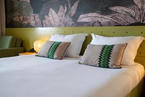 苏佩塔尔Labranda Velaris Resort的一张带两个枕头和墙壁的白色床