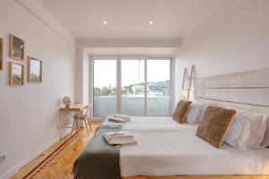 里斯本Belém River Apartment View的一间卧室设有一张大床和大窗户