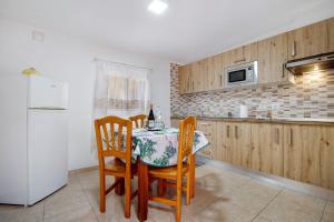 安提瓜Casa Cactus的厨房配有桌椅和冰箱。
