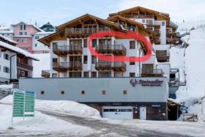 上陶恩Steinadler Seekareck FL - Skiing Holiday in Obertauern的雪上有红色标志的建筑