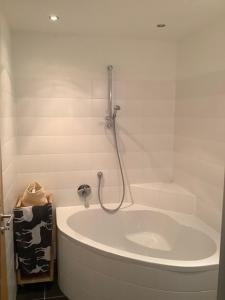 上陶恩Steinadler Seekareck FL - Skiing Holiday in Obertauern的浴室设有带淋浴的白色浴缸。