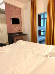 圣马力诺约里酒店的卧室配有一张大白色床和电视。