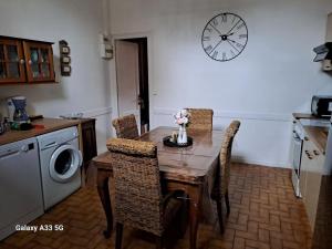 阿卡雄Villa Thomas的厨房配有桌椅和墙上的时钟
