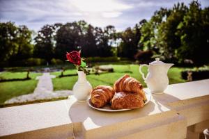 Vallon-sur-GéeChâteau de la Grange Moreau的一块糕点和玫瑰花瓶