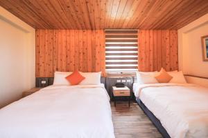 太平织丘庄园的配有木墙和窗户的客房内的两张床