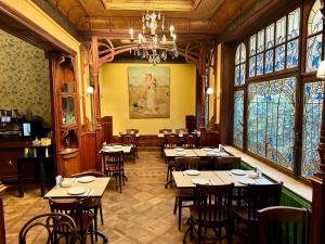 安特卫普Hotel Rubenshof的一间设有桌椅的餐厅,位于带窗户的房间内