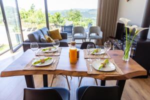 特拉什杜博鲁Casas de Bouro 2的木桌,带食物和酒杯盘