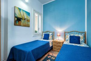 马尔萨拉Casa Marsala的一间蓝色卧室,配有两张床和窗户