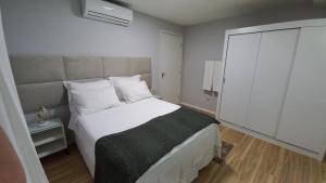 安格拉杜斯雷斯Studio Praia do Jardim 1 305B的卧室设有一张白色大床和一扇窗户。