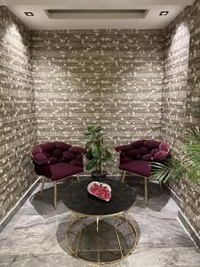 安塔利亚Bloomtalya Hotel的一间设有两张紫色椅子和一张桌子的房间