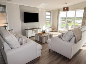 诺斯维奇44 Delamere Point的客厅配有2张白色沙发和1台平面电视