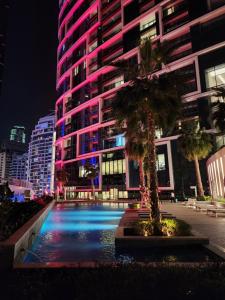 迪拜The Star @ Address Beach Residence的一座高大的建筑,前面有一棵棕榈树