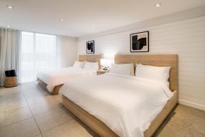 迈阿密海滩博兰南滩酒店的配有白色床单的酒店客房内的两张床