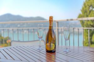 布里维奥[Como-Blevio] Suite lake view + private garage的桌子上放有一瓶香槟和两杯酒杯
