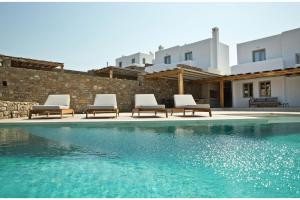 DexamenesSuper Luxury Mykonos Villa - Villa La Isla Bonita - Private Gym - Private Pool - 5 Bedrooms - Sea Views的一组椅子坐在游泳池旁