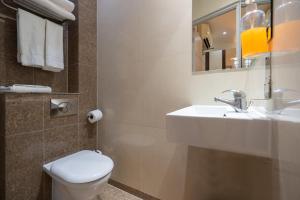 伦敦简朴客房&套房酒店的一间带水槽、卫生间和镜子的浴室