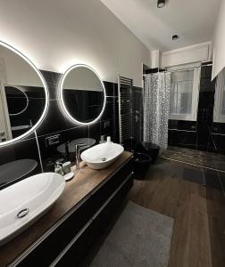PioltelloGreen Apartment的黑白浴室设有两个盥洗盆和淋浴。
