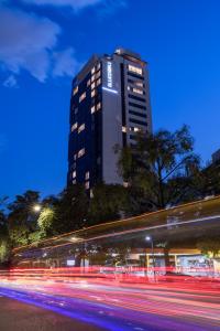 麦德林Hotel York Luxury Suites Medellin by Preferred的夜晚高大的建筑,灯火 ⁇ 