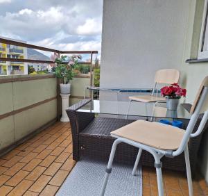 格拉茨BrightCenterApartment的阳台配有两把椅子和一张桌子