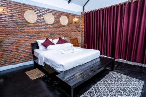 马德望Bat Rice Resort的一间卧室设有一张床和砖墙