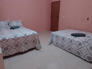 拉巴拉德纳圣安东尼奥Casa Praia Ilha da Croa/Carro quebrado的卧室设有两张粉红色的床铺。