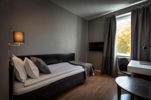 舍夫德约尔酒店的一间卧室配有一张床、一张书桌和一个窗户。