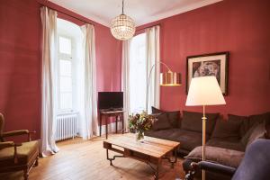 埃尔特维勒卡普豪森巴瑞尔酒店的客厅设有红色的墙壁、一张沙发和一张桌子