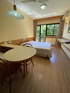 弗洛里亚诺波利斯Canto da Ilha的酒店客房配有一张床铺和一张桌子。