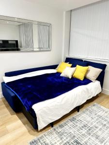 曼彻斯特1 Bed Apartment near Old Trafford with free car park的一张大蓝色的床,配有黄色枕头