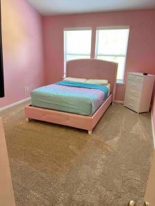 杰克逊维尔Townhome Baptist South St JohnsTownCenter Beach的粉红色的卧室,配有床和梳妆台