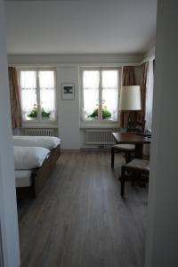 Melchnau加斯索夫鲁汶酒店的卧室配有一张床、一张书桌和窗户。