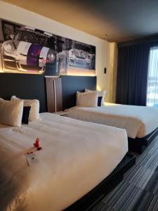 莱维斯Grand Hotel Times Levis的两张位于酒店客房的床,上面有红花