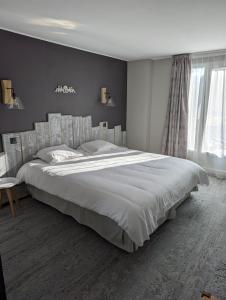 阿雷特Hôtel de l'Ours的一间卧室设有一张大床和一个窗户。