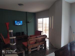 San LorenzoEstancia Spondylus的客厅配有沙发和墙上的电视