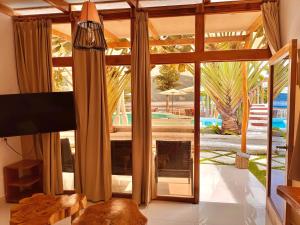 圣佩德罗拉拉古纳Sababa Resort的客厅设有通往游泳池的大玻璃门