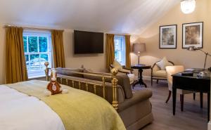 纽马基特贝德福德洛奇酒店及水疗中心的一间卧室配有一张床、一张沙发和一台电视