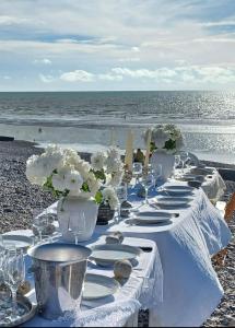 索姆河畔的圣瓦列里Gîte d’Eros的海滩上一张长桌,上面有盘子和花瓶
