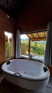 索科罗REFUGIO PIEMONTE Chalés的窗户客房内的白色大浴缸