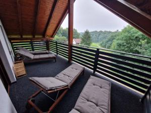 Donji KoncovčakHoliday Home Rajf的门廊上设有椅子和床罩