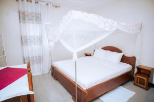 MuhariPeace Guest House的一间卧室配有一张带天蓬的床