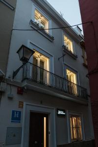 塞维利亚Sevilla DosTorres的一座带灯光阳台的建筑