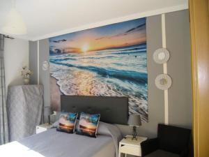 托雷德尔马尔Atalaya del Mar的一间卧室,配有一幅大幅海洋画