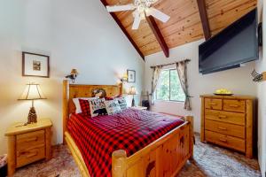 巴斯莱克Wishing Well Cabin的一间卧室配有一张木床和一台平面电视。
